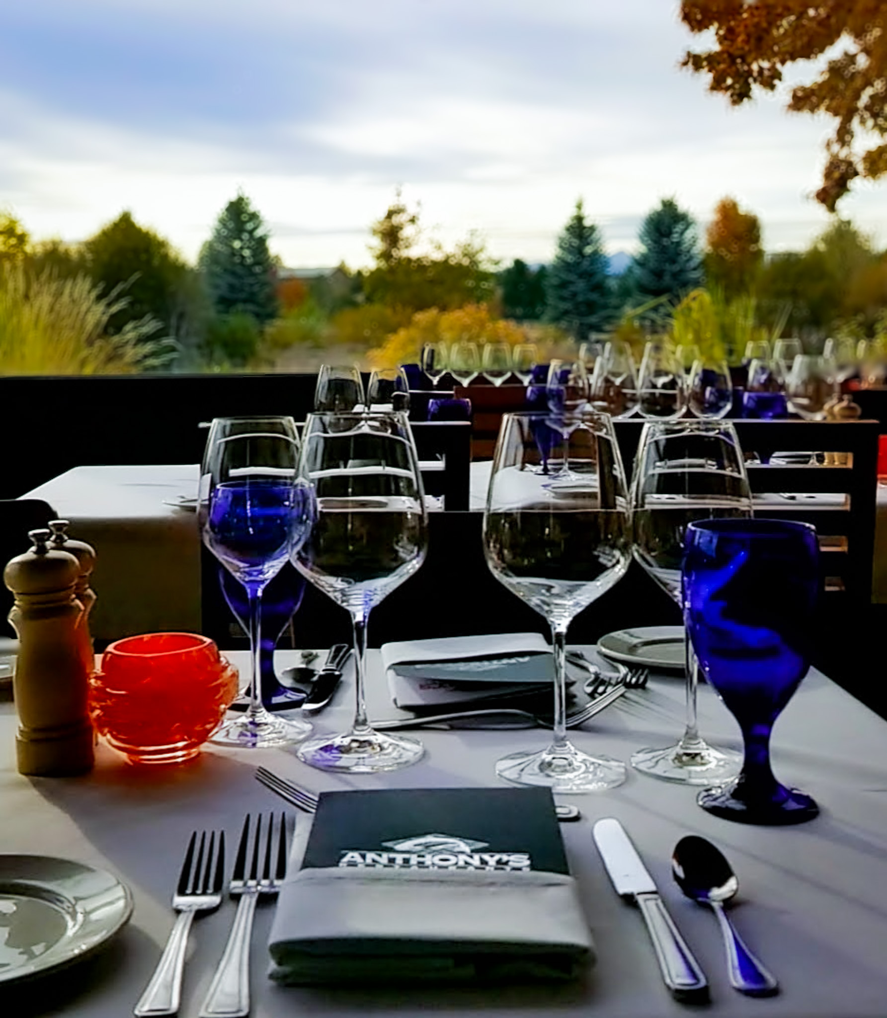 Wine glasses on formal dining table overlooking fall color on the Deschutes River